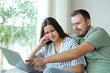 © Antonioguillem - Disappointed couple checking personal computer at home