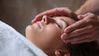 © BONI - Mujer recostada con los ojos cerrados recibiendo sesión de reiki o sanación energética con manos sobre su rostro