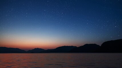 Wall Mural - a a movement of stars in the night sky with the view of mountains.