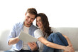 © ty - Young couple watching media content online in a tablet sitting on a sofa on a transparent background