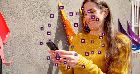 Poster - image of globe of digital icons over caucasian woman using smartphone outdoors