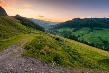Wall Mural - rural landscape in summer. carpathian range. village in the valley at dawn. forest and green meadow 