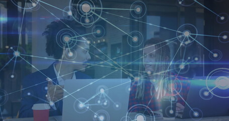 Poster - Image of network of connections over two caucasian businessmen using laptop at cafe