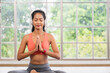 © weedezign - young healthy asian woman practice yoga on a mat at home in a yoga sitting position