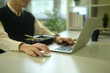 © Prathankarnpap - Close up of man using a laptop and mouse while having lunch at a desk