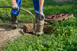 © retbool - pumping water from a cesspool, a man holds a vacuum pump over a cesspool, pumping out a home septic tank with a pump