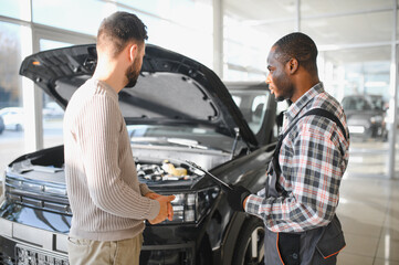 Fototapete - Man on the result of the work of a mechanic. The client evaluates the repair of the car by a mechanic