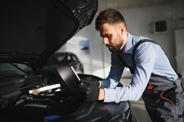 Fototapete - Automotive mechanic running diagnostics software on computer. Mechanic doing vehicle diagnostic test in auto service garage