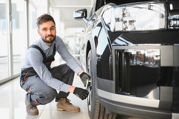 Aufkleber - Friendly mechanic in modern car repair shop with car. Professional technician checking vehicle diagnostics and maintenance. Concept of automotive industry and customer service