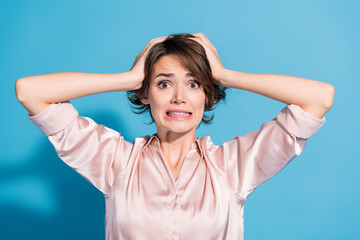 Aufkleber - Young woman in satin blouse expressing surprise against a blue background