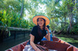 © themorningglory - Beautiful asian woman travel with local wooden boat in traditional floating market tropical forest river