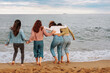 © bernardbodo - Friends hugging and getting their feet wet by the ocean