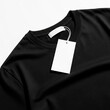 © Marlon - A closeup of a black t-shirt with a blank white hang tag on a white background, captured in a bright and clear environment.