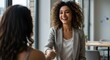 © youns - Un apretón de manos entre una empresaria o gerente de recursos humanos feliz, segura y entusiasmada y una colega, socia o empleada. Un acuerdo, trato o reunión con un compañero de trabajo en la sala d