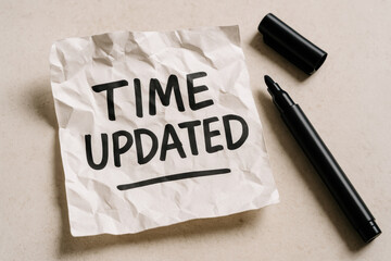 Poster - This symbolizes progress with a handwritten update note placed on a wooden surface beside a black marker reflecting time management and communication in business