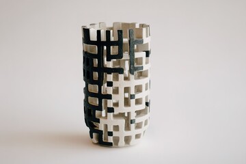 Poster - Decorative ceramic vase with modern geometric design in black and white colors displayed on a neutral background