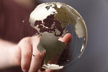 Fototapete - High-quality stock photo of a hand interacting with a transparent 3D globe, representing global connectivity and networking.