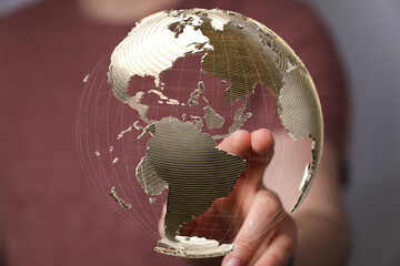 Fototapete - Person's hand interacts with a transparent 3D model of the Earth, symbolizing global connectivity.