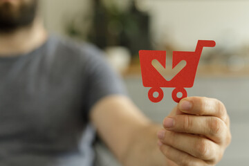 Aufkleber - Image depicts a person holding a paper shopping cart with a downward arrow, symbolizing online purchases and e-commerce.