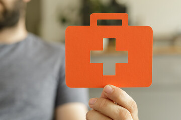 Poster - Person holding a first aid kit symbol. Healthcare, medical, health insurance concept.