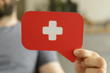 Poster - Red speech bubble with a white cross, symbolizing medical assistance or healthcare.