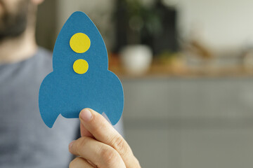 Poster - Image of a person holding a paper rocket, symbolizing new beginnings and business launch.