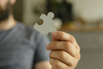 Aufkleber - Close-up of a person's hand holding a puzzle piece.  Represents solutions, teamwork, and problem-solving.