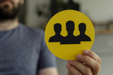 Aufkleber - Image of a person holding a yellow circle with three black silhouettes representing teamwork.