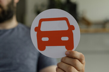 Aufkleber - Stock photo of a man holding a paper cutout of a car. Perfect for transportation, vehicle, or insurance concepts.