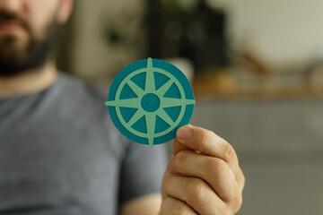 Aufkleber - A man holds a paper compass, symbolizing guidance, direction, and finding your way.