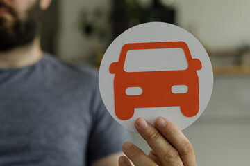 Aufkleber - Stock photo of a man holding a paper cut-out of a car, representing vehicle concepts.