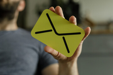 Aufkleber - Close-up of a person holding a yellow card with an envelope icon.  Concept for email, message, communication.