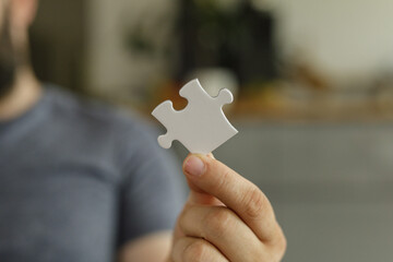 Aufkleber - A man holds a single white puzzle piece, symbolizing solutions, teamwork, and problem-solving.