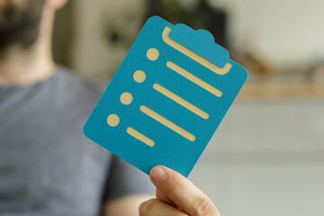 Aufkleber - Person holding a teal clipboard checklist.  Perfect for project management, to-do lists, and organization.