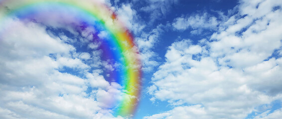 Wall Mural - bright rainbow in blue sky with clouds on sunny day. banner design