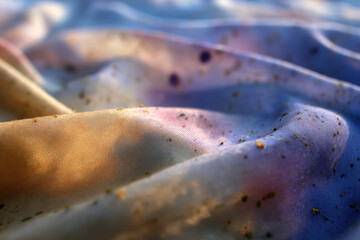 Aufkleber - Close up of colorful, textured fabric with scattered specks, resembling dreamy landscape. fabric surface is illuminated, highlighting its soft folds and vibrant hues