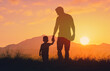 © kieferpix - Silhouette father and his son holding hands at sunset field. Dad leading son over summer nature outdoor. Family, trust, protecting, care, parenting concept