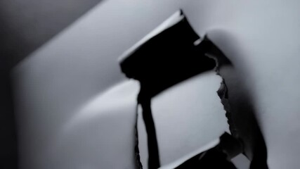Poster - Abstract shot of torn white paper showing a dark background, rough edges and textured surface with a ray of light striking the scene.