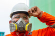 © agung - Construction worker wearing respirator, hard hat & safety glasses. Industrial safety, PPE, construction, health protection.