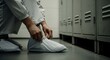 © Farhan - Worker Putting on Protective Shoe Covers in Industrial Locker Room