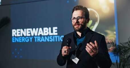 Poster - Microphone, presentation and businessman on a stage at seminar for renewable energy transition. Public speaker, conference and male environmental manager at convention for sustainability company.