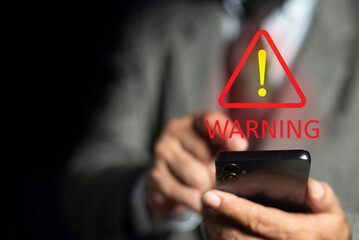 businessman using smartphone with triangle caution warning sign for notification error and maintenan