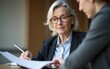 © car - Old female manager looking at tablet with paperwork with employee. High quality