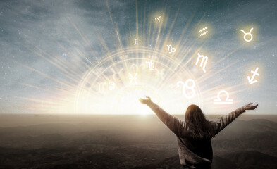 woman raising hands looking at the sky. astrological wheel, choose a zodiac sign. astrology and horo