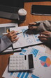 © Kansuda - Group of confident business people point to graphs and charts to analyze market data, balance sheet, account, net profit to plan new sales strategies to increase production capacity.