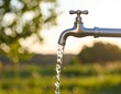 © Abhi - Close-up of water streaming in an arc in rural indian village,  from faucet mouth into empty space