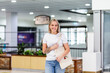 © Austockphoto - portrait of young Australian woman in her twenties out shopping at mall carrying tote bag