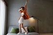 © SHOTPRIME STUDIO - Energetic young woman dancing joyfully in stylish outfit at home, showcasing vibrant colors, emotions, and a modern interior design