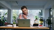 © stockbusters - Business consultant talking smartphone at desk in modern coworking space closeup