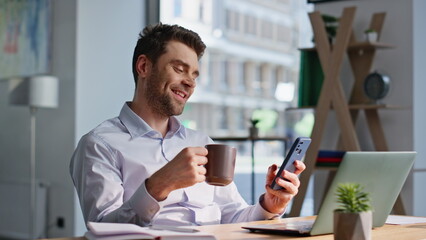 Poster - Office man holding coffee cup browsing social media at smartphone closeup. 